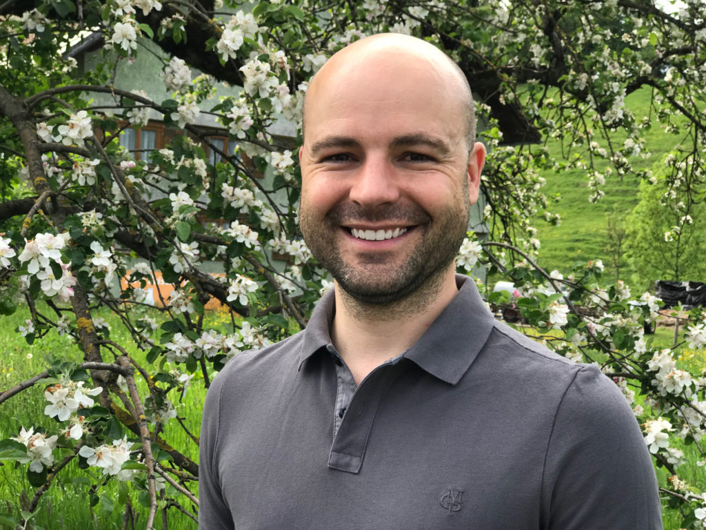 Portrait von Dr. Matthias Wucherer vor einem blühenden Apfelbaum im Allgäu