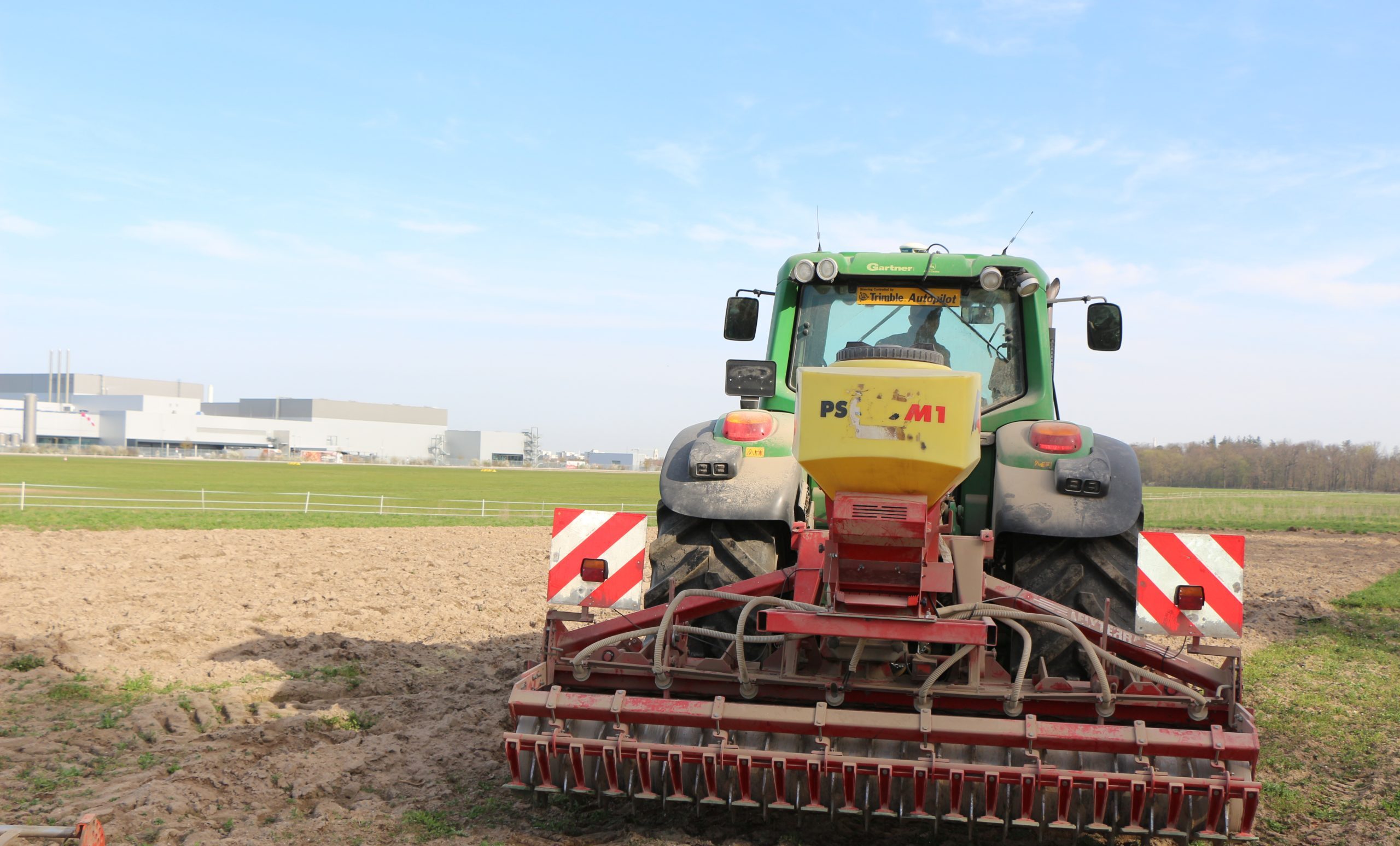 Eine pneumatische Sämaschine in Aktion bei der Aussaat der Mischung Blühende Landschaft auf dem Feld